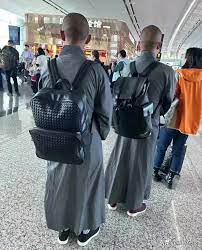 monks with luxury bag